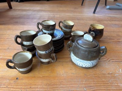 de nombreuses tasses et soucoupes posées sur une table en bois