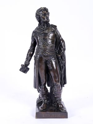 une statue antique en bronze représentant un homme portant un chapeau et un manteau