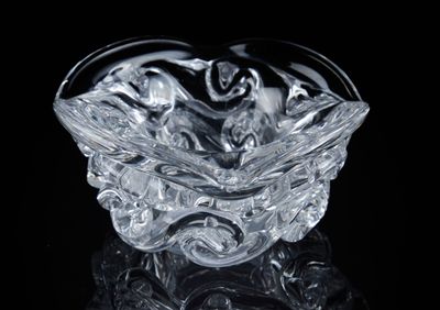 un saladier en verre posé sur une surface noire