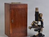 an old microscope with a wooden box and a wooden box