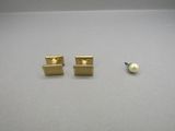 a pair of gold stud earrings with a pearl in the middle