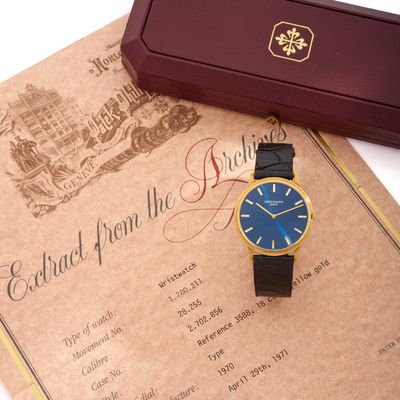 une montre posée sur une feuille de papier à côté d'une boîte