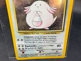 une carte Pokémon dans une boîte en plastique posée sur une table