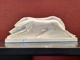 a white sculpture of a dog on a table