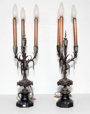 paire de bougeoirs anciens en bronze ornés de têtes de cerfs, posés sur un socle en marbre