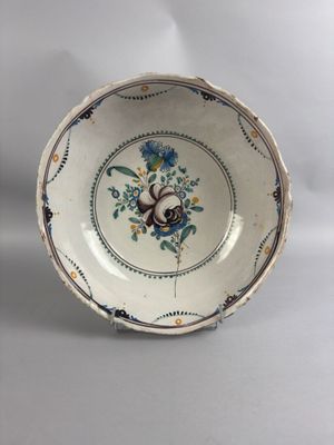 une vieille assiette bleue et blanche sur laquelle est représenté un oiseau