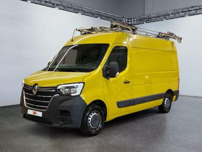 La camionnette jaune est garée dans une grande pièce aux murs blancs.