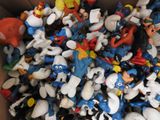 a cardboard box full of toy figurines of cartoon characters