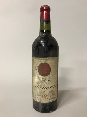 une vieille bouteille de vin posée sur une table blanche