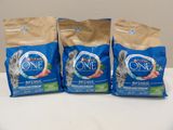 trois sacs de nourriture pour chat posés sur une table