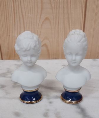 deux bustes blancs posés sur un plateau de table en marbre