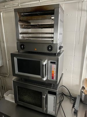 trois micro-ondes empilés les uns sur les autres dans une cuisine