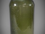 a green glass vase that is sitting on a table