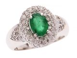 gros plan d'une bague avec une pierre verte entourée de diamants blancs