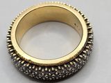 a close up of a gold ring with black and white diamonds