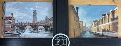 deux tableaux accrochés au mur d'un immeuble sur lequel se trouve une horloge