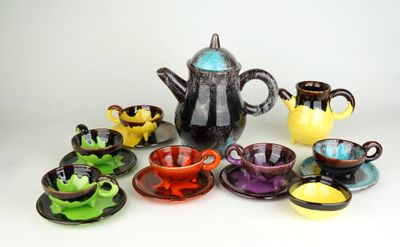 tout un assortiment de tasses et soucoupes de différentes couleurs, ainsi qu'une théière