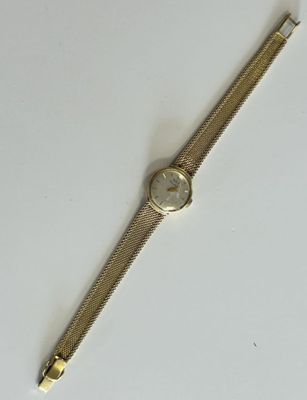 a gold wrist watch on a white surface with a white background
