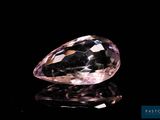 a close up of a pink diamond on a black surface