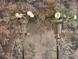 deux vases en argent contenant des fleurs, posés sur une table