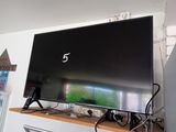 une télévision à écran plat posée sur une étagère en bois