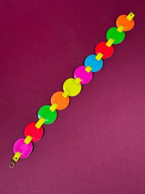 a close up of a colorful bracelet on a purple background