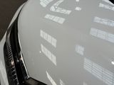 a close up of a car ' s headlight with a building in the background