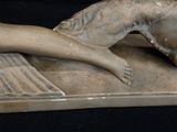a statue of a woman laying down on a table