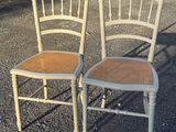 two chairs sitting next to each other on a gravel road