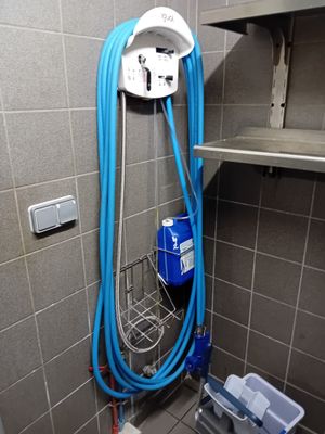 un tuyau bleu fixé au mur d'une salle de bains