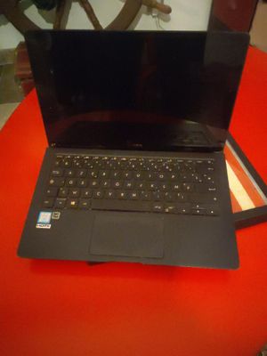 un ordinateur portable ouvert posé sur une table rouge