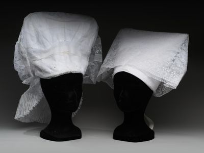 deux têtes de mannequin noires recouvertes d'un tissu blanc
