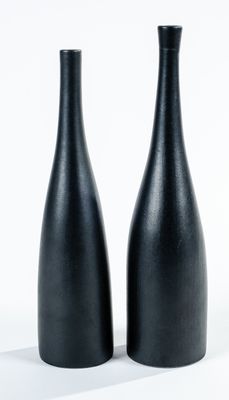deux vases noirs posés sur une surface blanche
