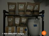 many bags of food sitting on a shelf next to a barrel