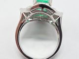 a close up of a ring with a green stone