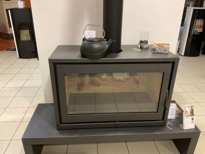 un réchaud sur lequel est posée une bouilloire, au milieu d'une pièce