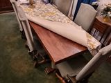 a long table with chairs and a table cloth on it