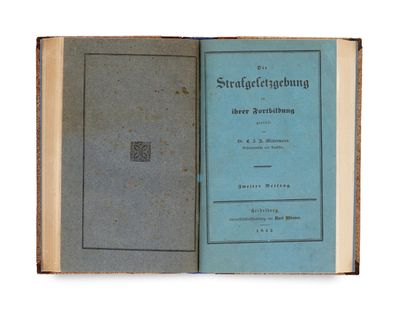 an old book with a blue cover sitting on top of a table