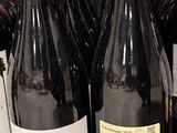 several bottles of wine are lined up on a shelf in a store