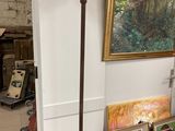 a lamp that is sitting on a table in front of a painting