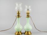 une paire de lampes en verre vert avec des ferrures en laiton