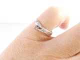 a woman ' s hand with a diamond ring on it
