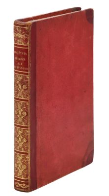 un vieux livre à la couverture rouge posé sur une surface blanche