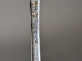 a silver spoon with a bird on it that is sitting on top of it