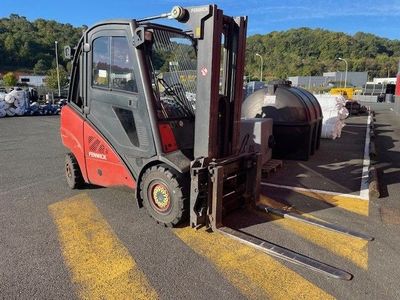 un chariot élévateur rouge garé sur un parking