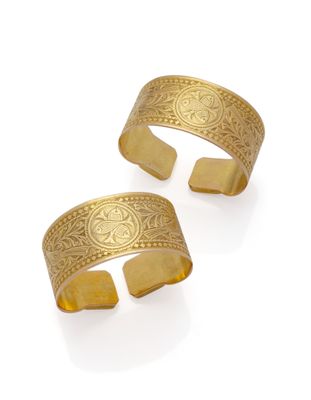 une paire de bracelets manchette en or ornés de motifs gravés