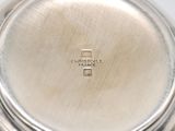 an image of a close up of a silver plate with a cross on it