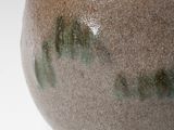 a brown and green bowl sitting on a white table