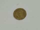 a close up of a gold coin on a white surface