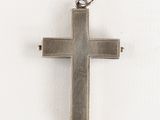silver cross on a white background with a black cord